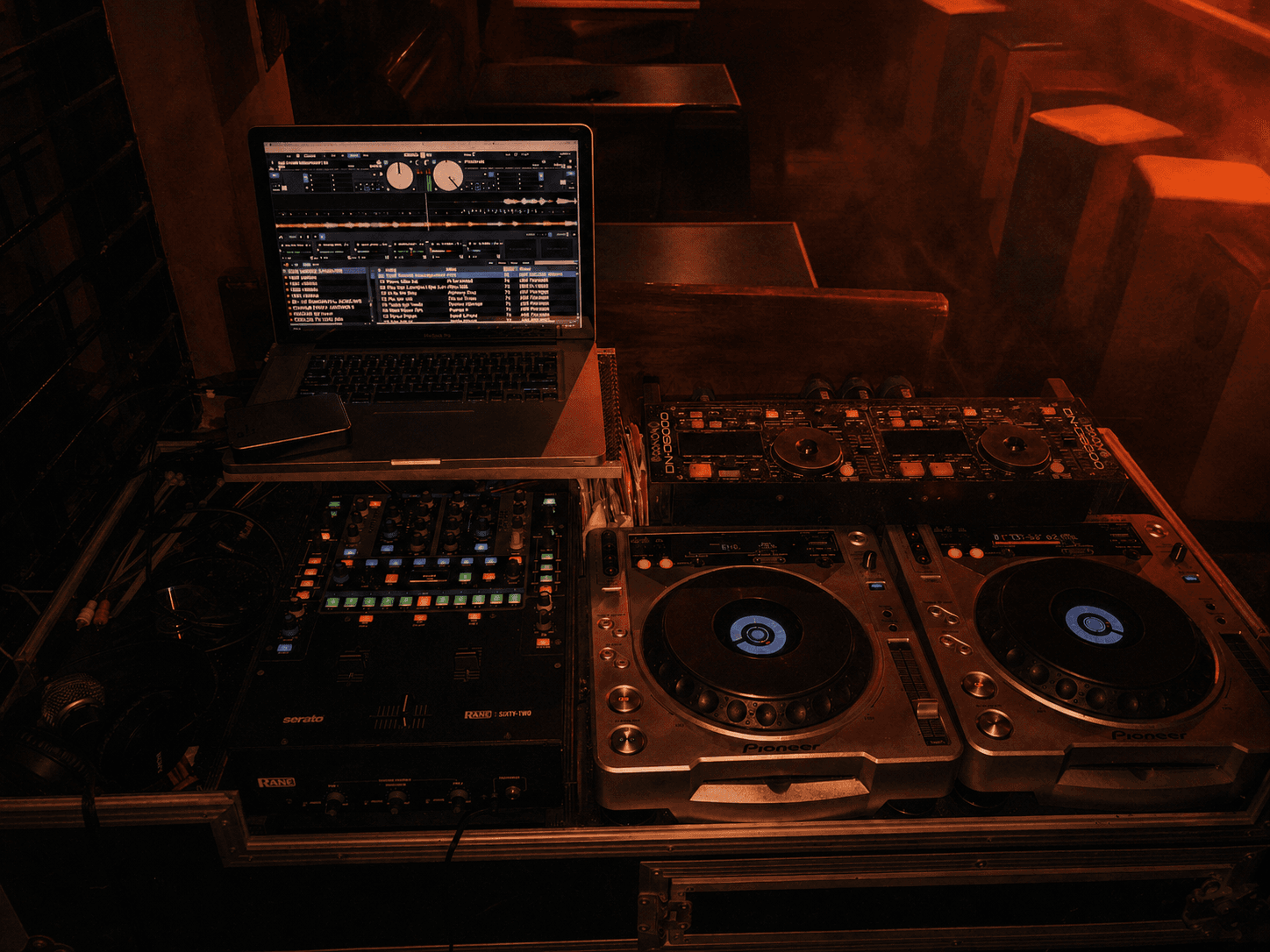 DJ decks and mixing console inside the Exodus Nuclear venue in cinematic red light
